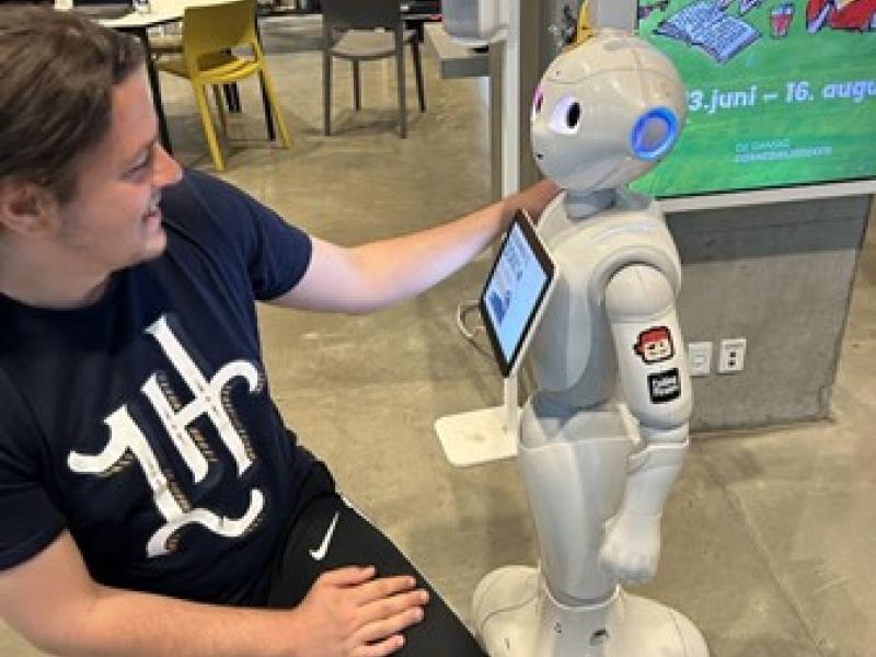 Robotten Norma ses i hyggelig samtale med ITK's medarbejder